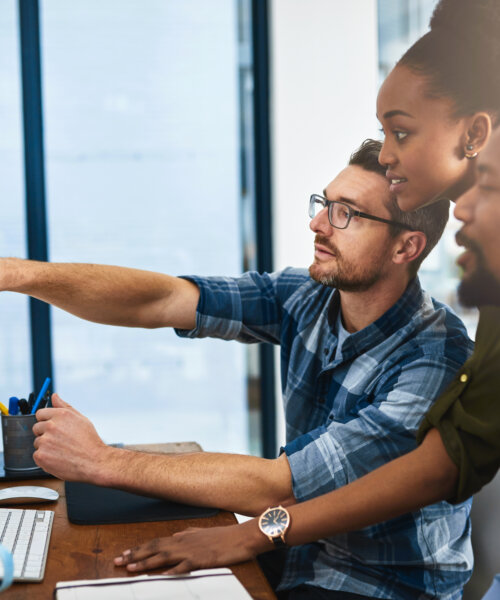 Cropped shot of three businesspeople working around a computer in the office